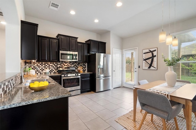 kitchen with stainless steel appliances, backsplash, hanging light fixtures, a sink, and visible vents