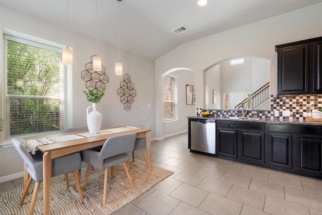 kitchen with backsplash, visible vents, arched walkways, and stainless steel dishwasher