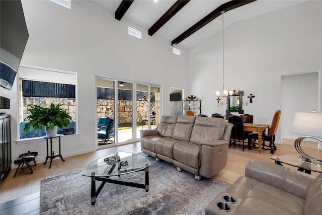 living room with an inviting chandelier, high vaulted ceiling, light hardwood / wood-style floors, and beamed ceiling