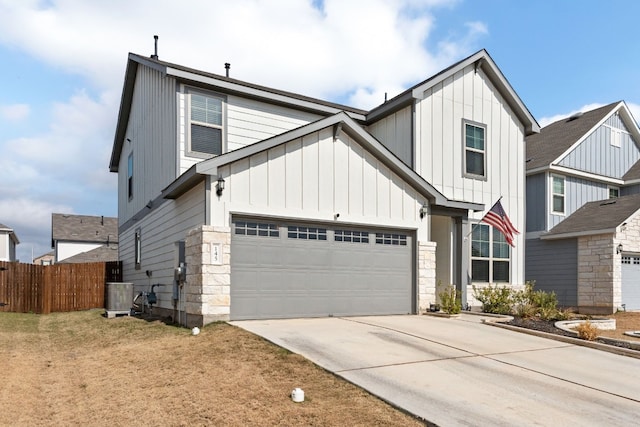 view of front of home featuring central AC, a garage, and a front lawn