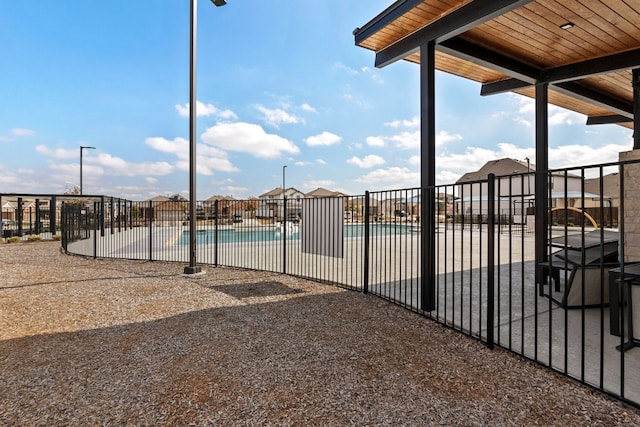 pool with a patio area and fence