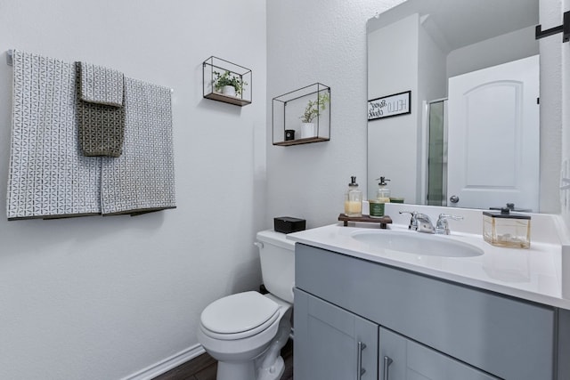 full bathroom with toilet, vanity, and baseboards