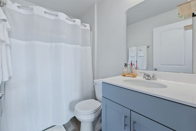 bathroom with toilet, curtained shower, wood finished floors, and vanity