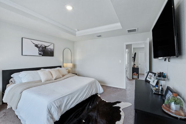 bedroom with carpet floors, a tray ceiling, visible vents, and baseboards