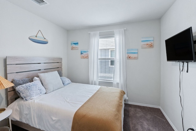 bedroom with dark colored carpet, visible vents, and baseboards