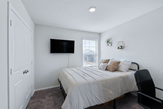 bedroom featuring dark colored carpet and baseboards