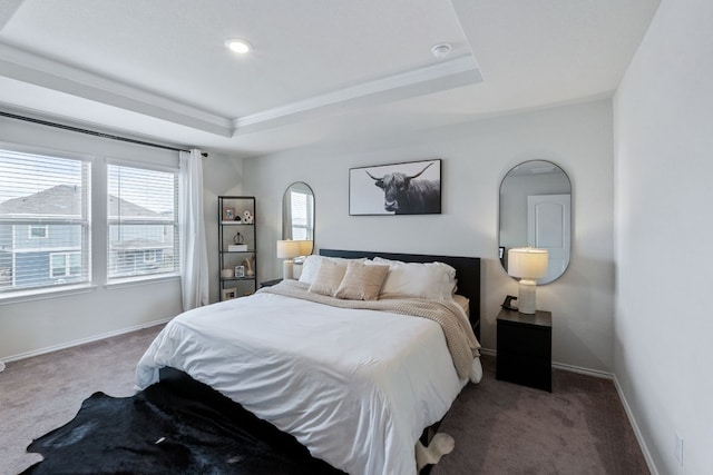 carpeted bedroom featuring baseboards and a tray ceiling