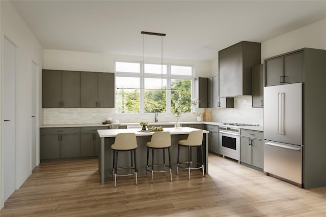 kitchen with a kitchen island, tasteful backsplash, gray cabinetry, stainless steel appliances, and wall chimney exhaust hood