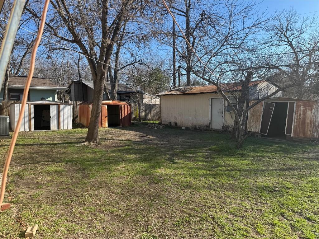 view of yard with central AC and a shed