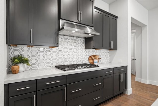 kitchen with tasteful backsplash, stainless steel gas stovetop, and light hardwood / wood-style floors