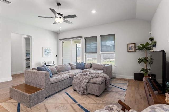 living room with lofted ceiling, ceiling fan, and light hardwood / wood-style flooring