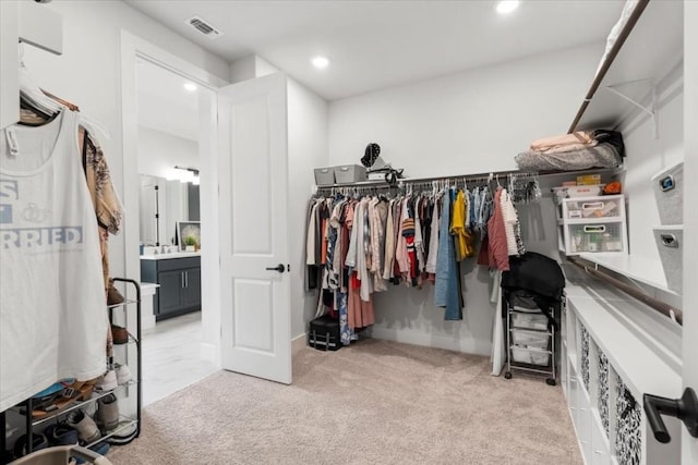 walk in closet featuring light colored carpet and sink