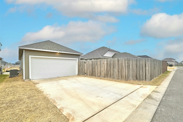 view of home's exterior featuring central AC, fence, a shingled roof, and a garage