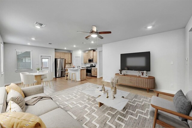 living area featuring ceiling fan, light wood finished floors, baseboards, visible vents, and recessed lighting