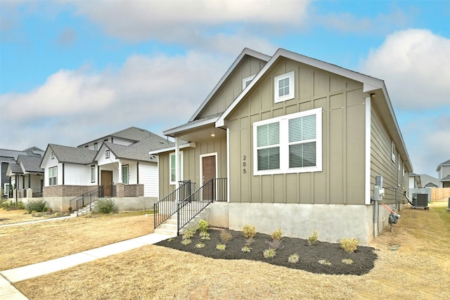 view of front of house featuring board and batten siding, a residential view, and cooling unit