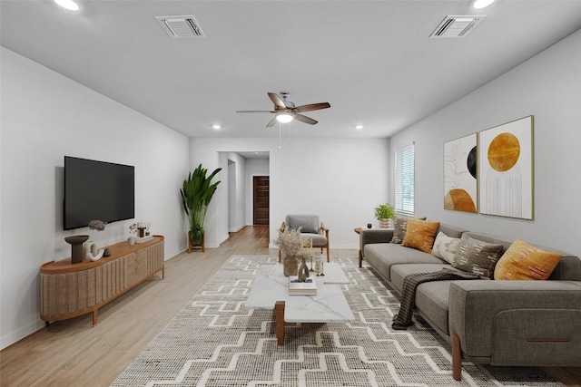 living area with light wood-type flooring, a ceiling fan, visible vents, and recessed lighting
