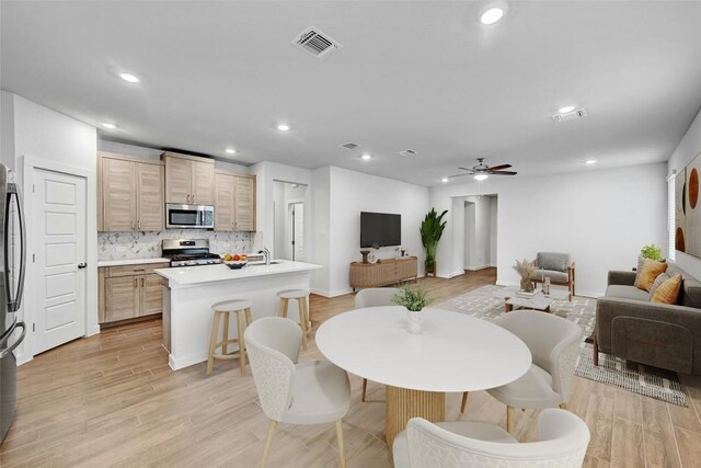 dining space with a ceiling fan, light wood finished floors, visible vents, and recessed lighting