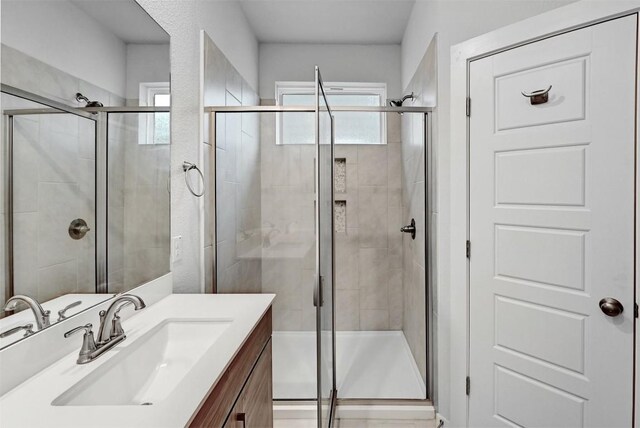 bathroom featuring vanity and a shower with shower door