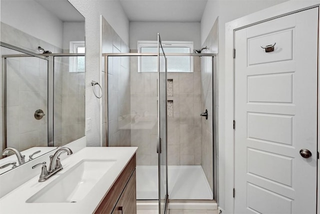 bathroom with a shower stall and vanity