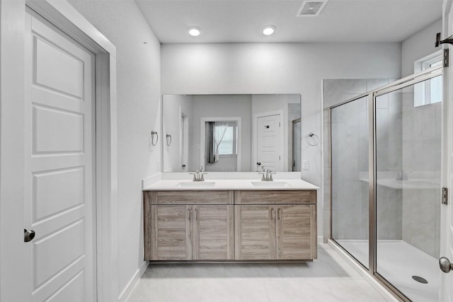 bathroom featuring vanity, an enclosed shower, and tile patterned floors