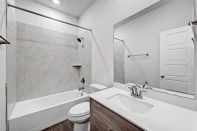 full bathroom featuring wood-type flooring, toilet, tiled shower / bath combo, and vanity