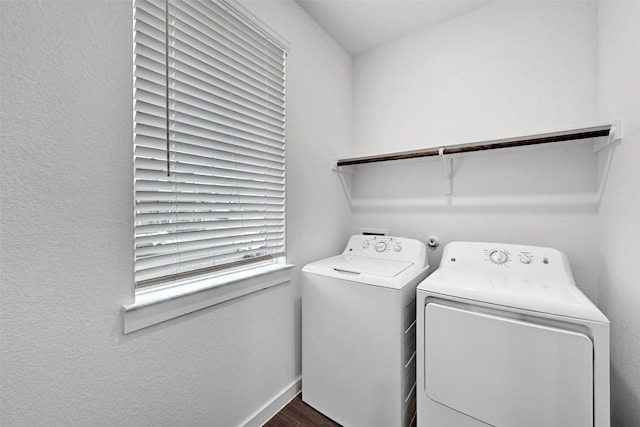 laundry area featuring separate washer and dryer, baseboards, laundry area, and dark wood finished floors