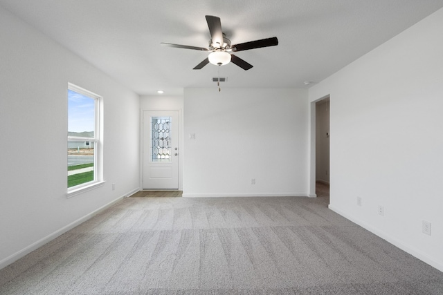 unfurnished room featuring light carpet and ceiling fan