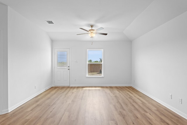 empty room with vaulted ceiling, ceiling fan, and light hardwood / wood-style flooring