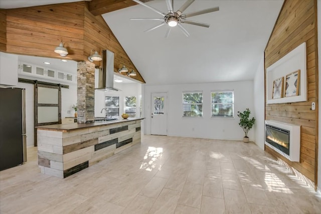 living room with sink, a barn door, high vaulted ceiling, and heating unit