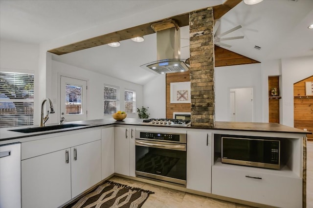 kitchen with sink, appliances with stainless steel finishes, white cabinetry, island range hood, and kitchen peninsula