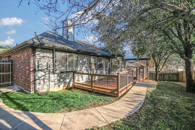 view of property exterior with a lawn and a deck