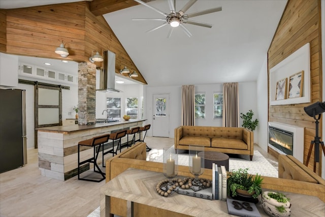 living room featuring high vaulted ceiling and a barn door