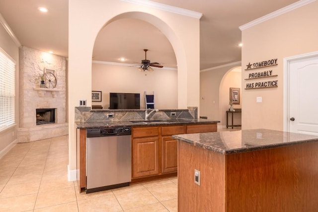 kitchen featuring sink, a fireplace, ornamental molding, and dishwasher