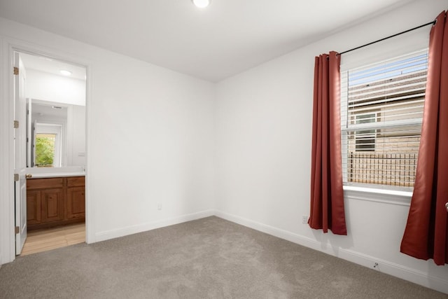 unfurnished room featuring a healthy amount of sunlight and light carpet