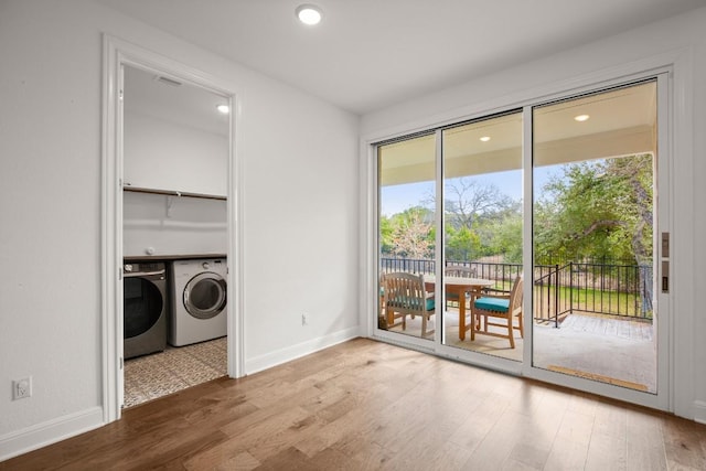 clothes washing area featuring separate washer and dryer and wood-type flooring