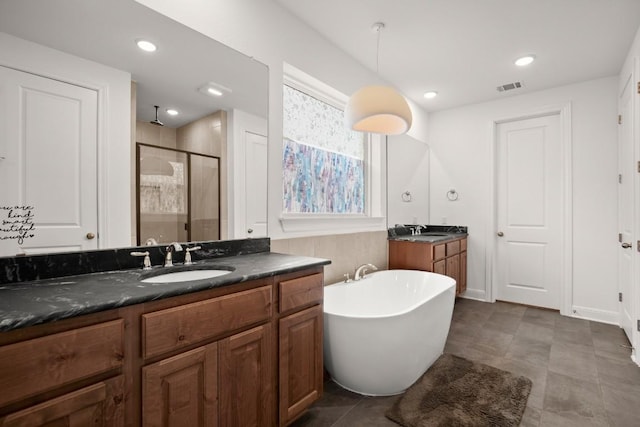 bathroom with vanity and separate shower and tub