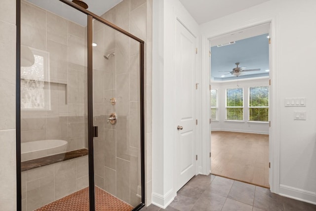 bathroom with ceiling fan, a shower with shower door, and tile patterned flooring