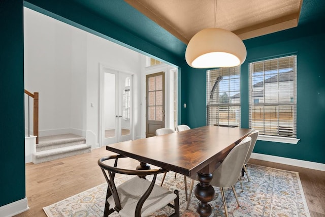 dining space with wood-type flooring and french doors