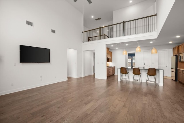 living room featuring ceiling fan, dark hardwood / wood-style floors, and sink