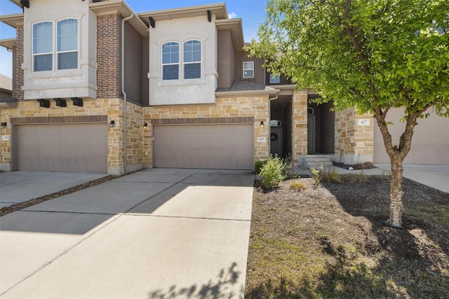 view of front facade featuring driveway, stone siding, an attached garage, and stucco siding