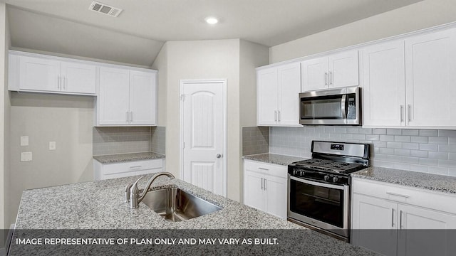 kitchen featuring light stone counters, sink, stainless steel appliances, and white cabinets