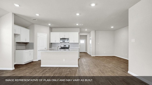 kitchen featuring stainless steel appliances, white cabinetry, a kitchen island with sink, and hardwood / wood-style floors