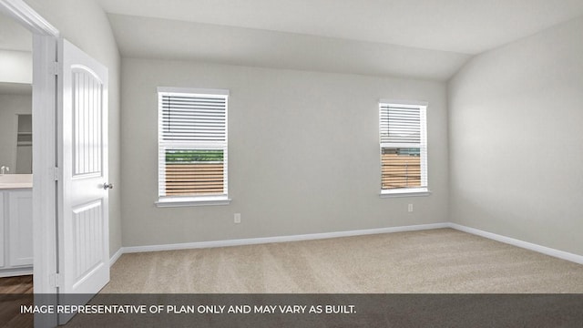 unfurnished room featuring light colored carpet and vaulted ceiling