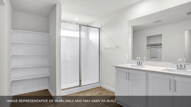 bathroom with wood-type flooring, vanity, and a shower with shower door