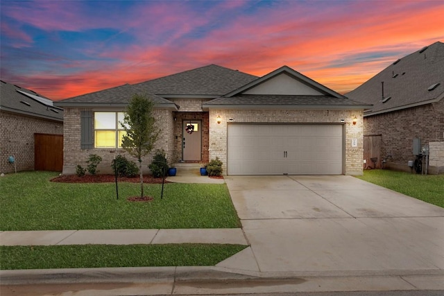 view of front of home with a garage and a yard