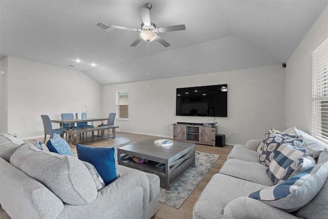 living room with ceiling fan, lofted ceiling, and light wood-type flooring