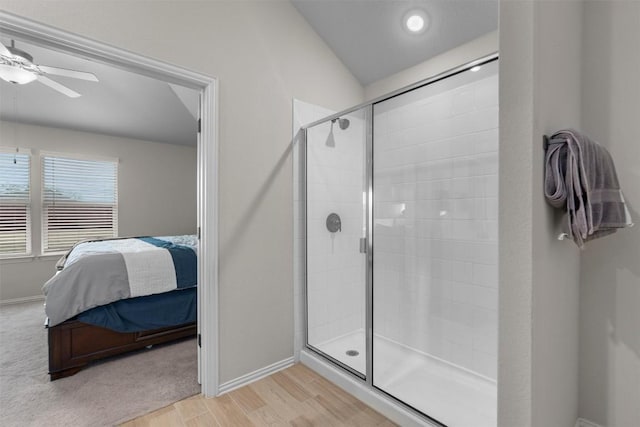 bathroom featuring hardwood / wood-style floors, vaulted ceiling, ceiling fan, and walk in shower