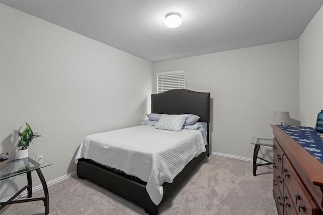 bedroom with light colored carpet and a textured ceiling