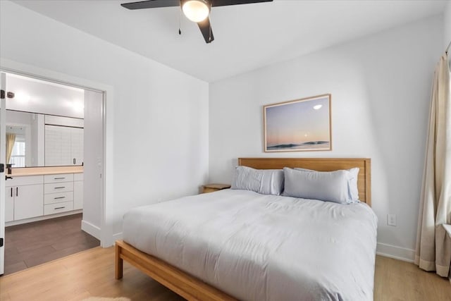 bedroom with ceiling fan, ensuite bath, and light hardwood / wood-style flooring