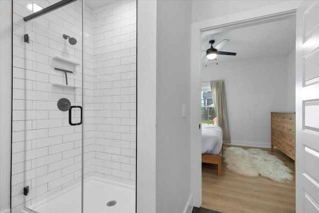 bathroom with ceiling fan, wood-type flooring, and a shower with shower door